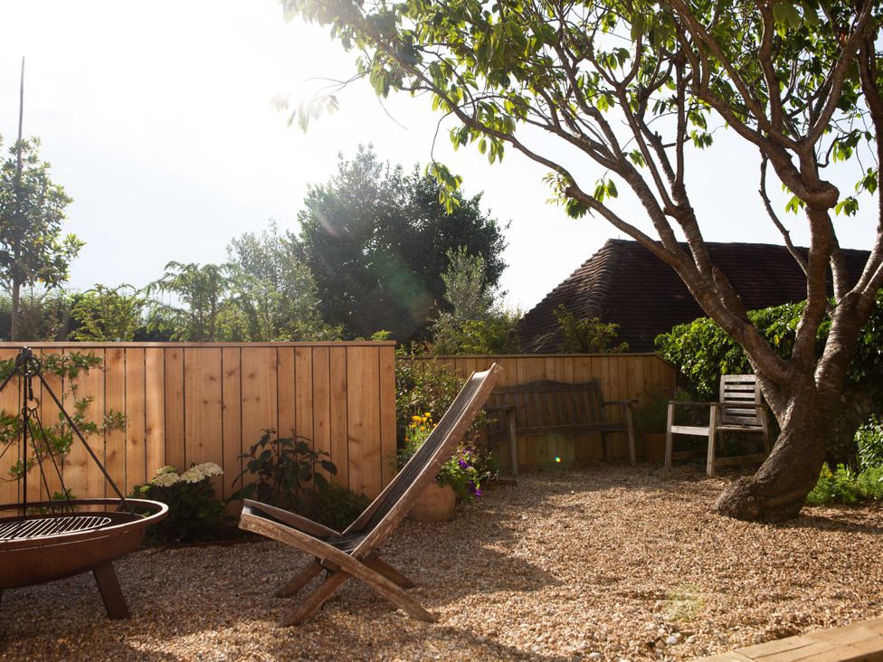 A garden with a deckchair and gravel at Newstead Farmhouse in East Chiltington near Lewes, Sussex