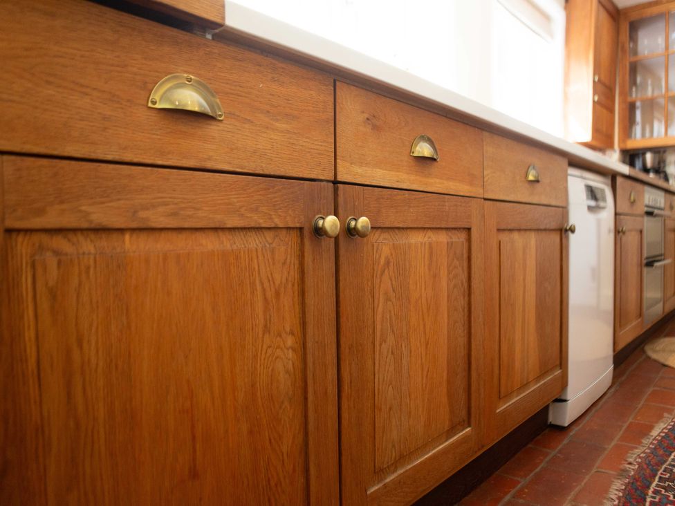A kitchen with wooden cabinets and brass handles at Newstead Farmhouse East Chiltington near Lewes Sussex