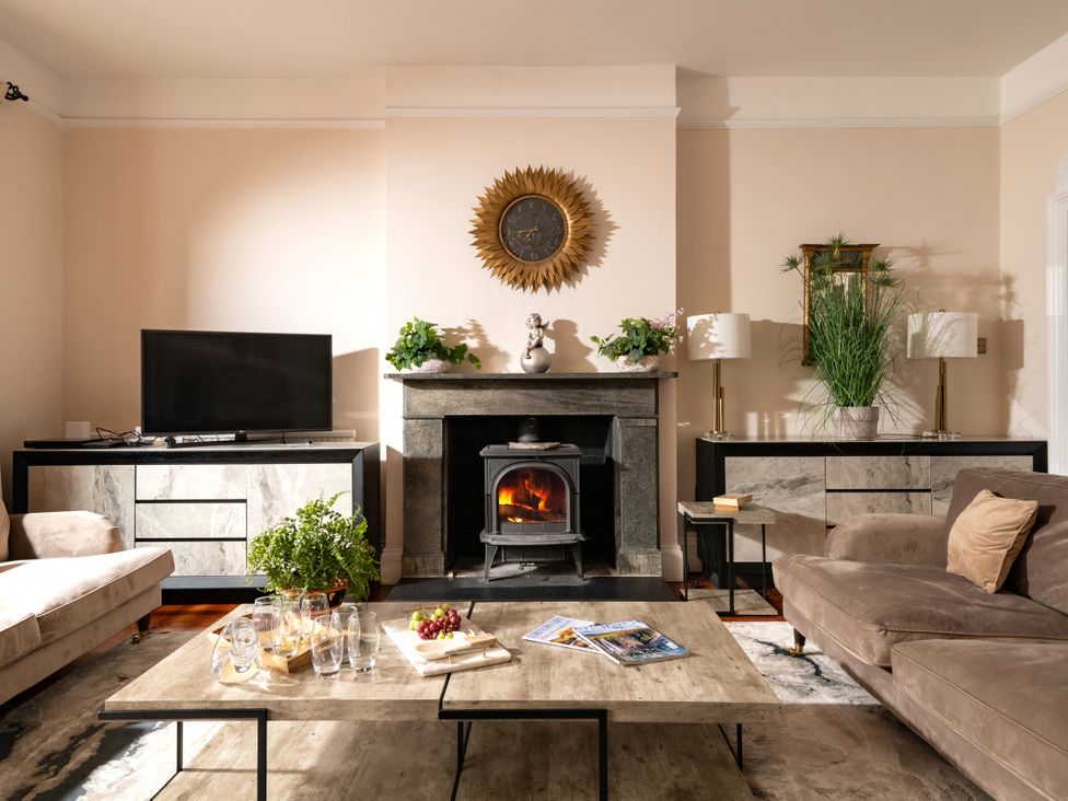 A living room with a fireplace and television at The Downwood in Blandford Forum