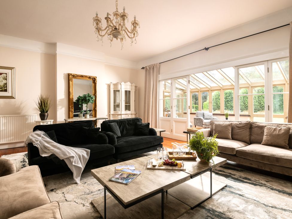 A living room with sofas and a chandelier at The Downwood in Blandford Forum