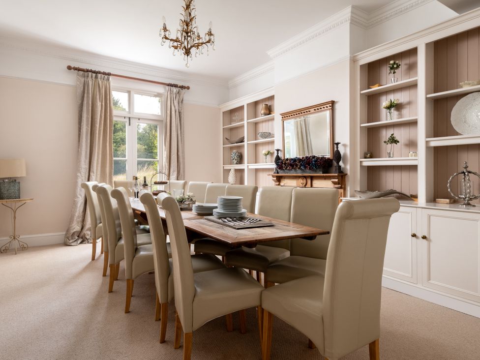 A dining room with a large table and chairs at The Downwood in Blandford Forum