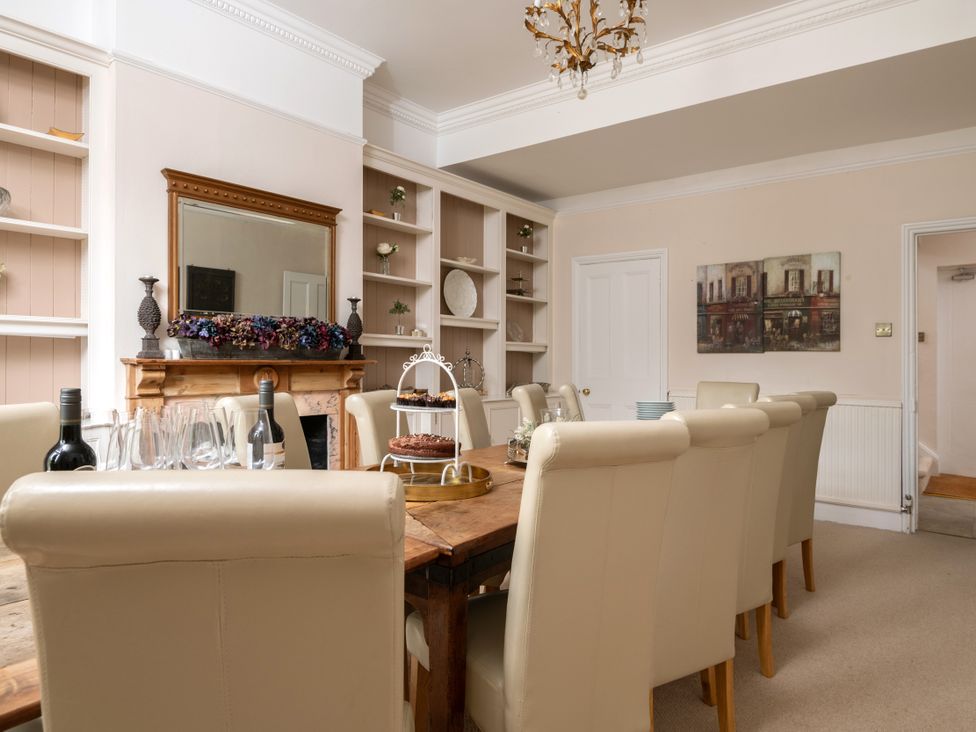A dining room with a wooden table and chairs at The Downwood in Blandford Forum