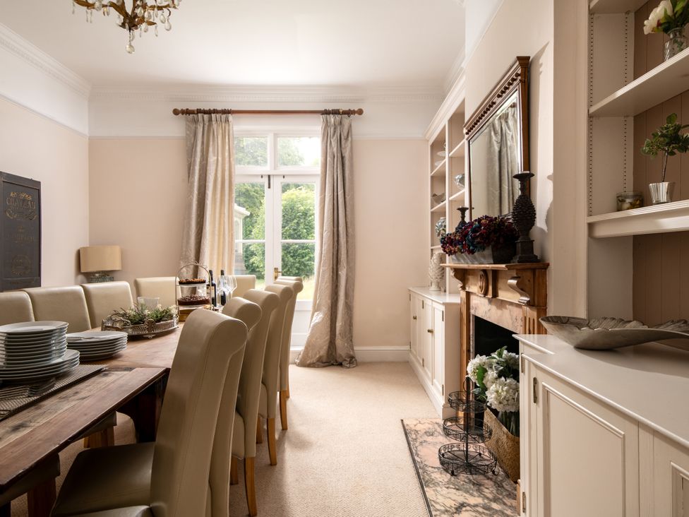 A dining room with a long table and chairs at The Downwood in Blandford Forum