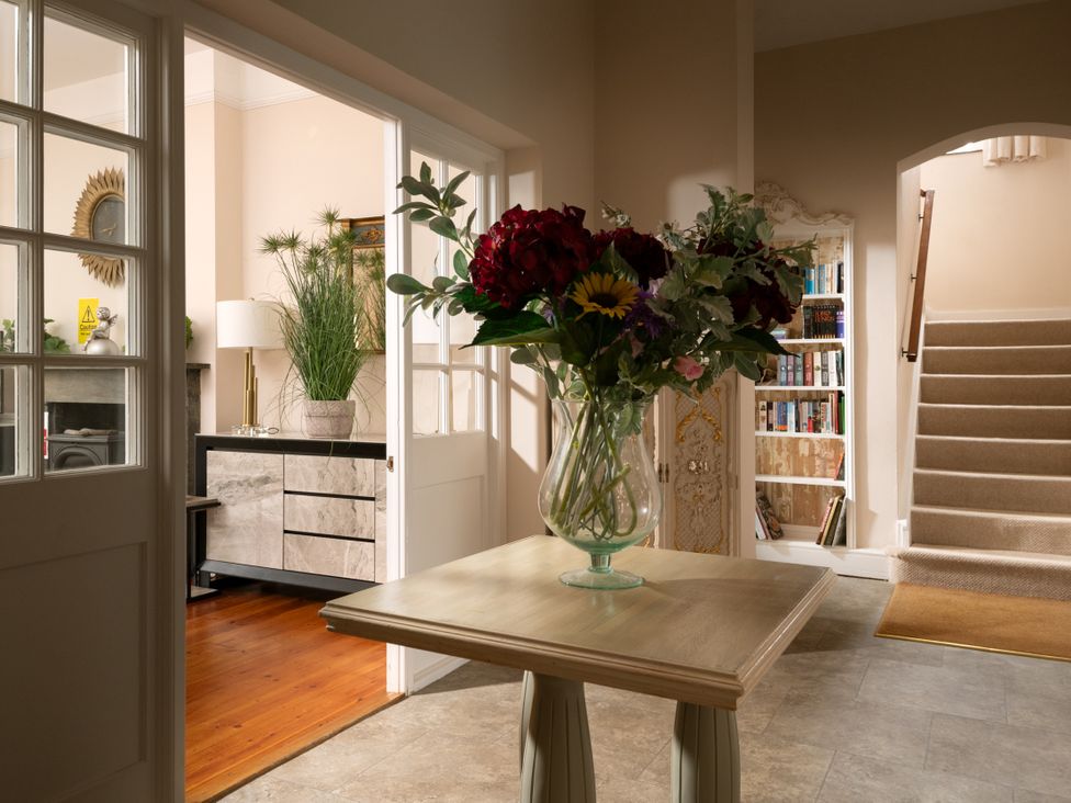 A hallway with a table and flowers at The Downwood in Blandford Forum