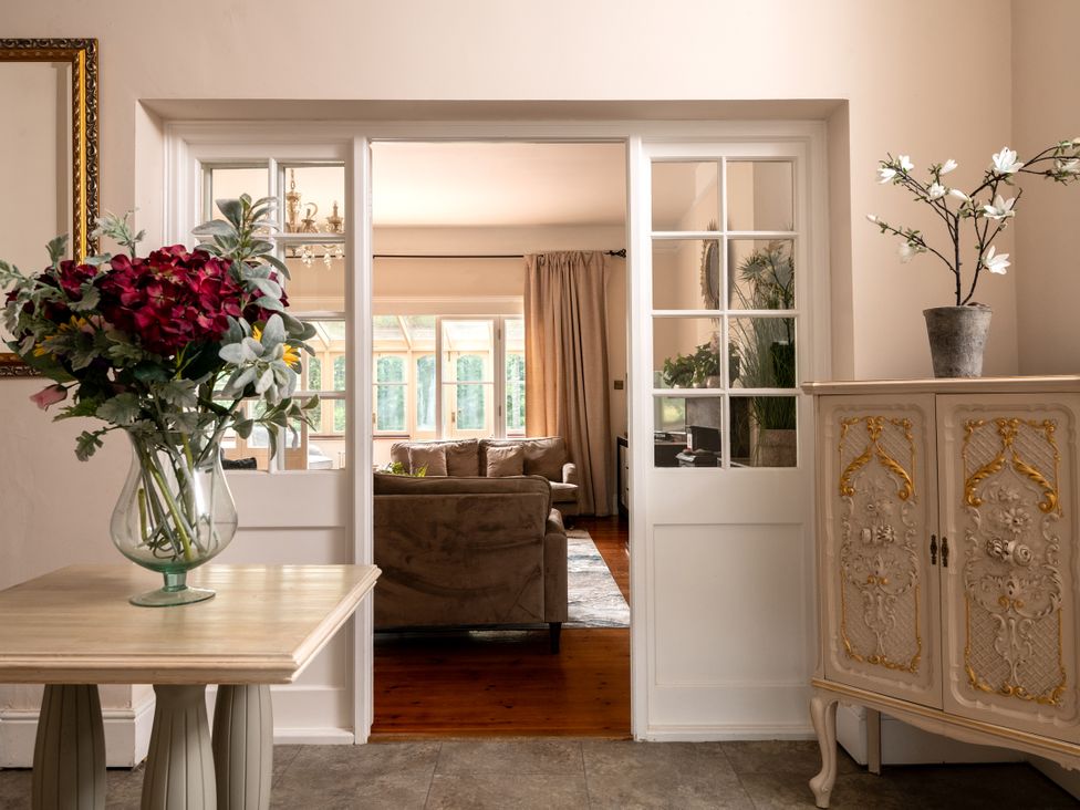 A living room with a view to a sofa and a cabinet at The Downwood in Blandford Forum