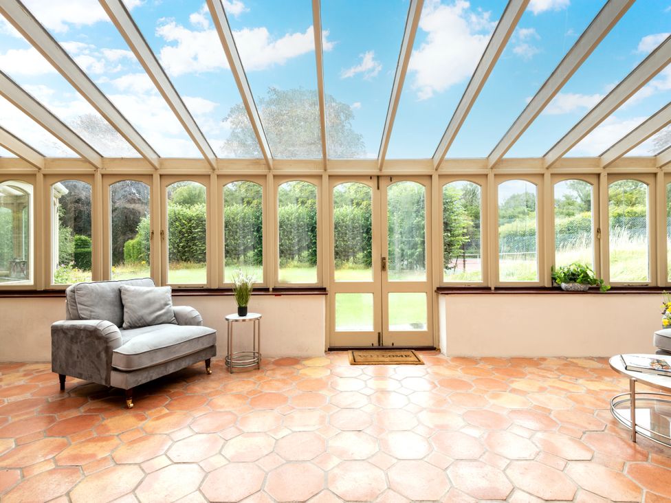 A conservatory with a sofa and coffee table at The Downwood in Blandford Forum