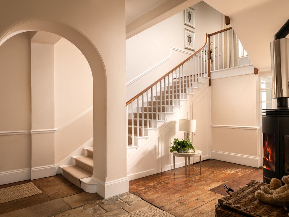 A staircase with a lamp and potted plant in the hallway at The Downwood in Blandford Forum