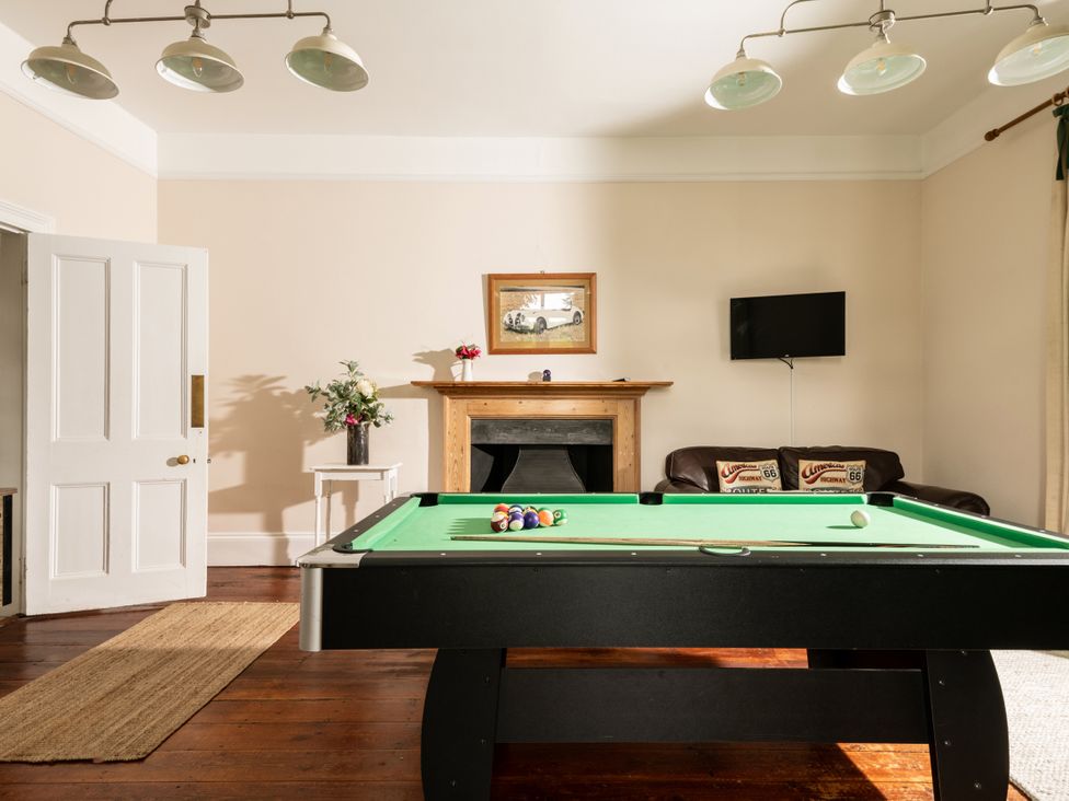 A game room with a pool table and a television at The Downwood in Blandford Forum