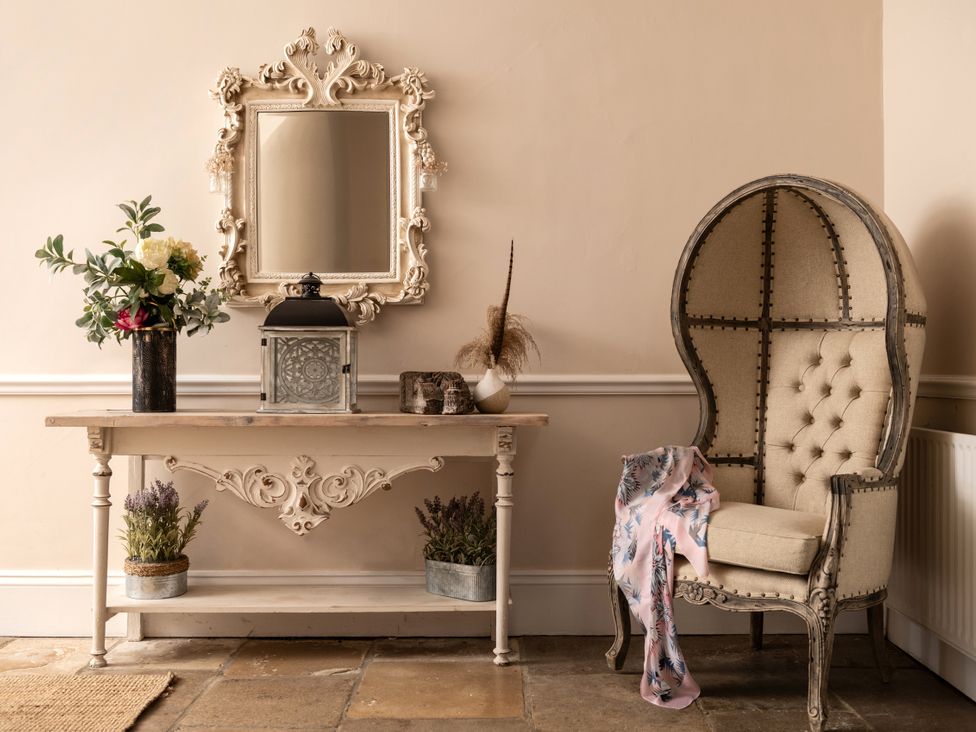 A hallway with a mirror and a table at The Downwood in Blandford Forum