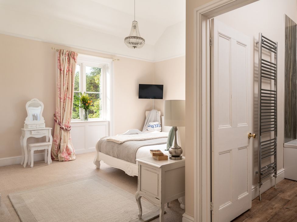 A bedroom with a bed and television at The Downwood in Blandford Forum