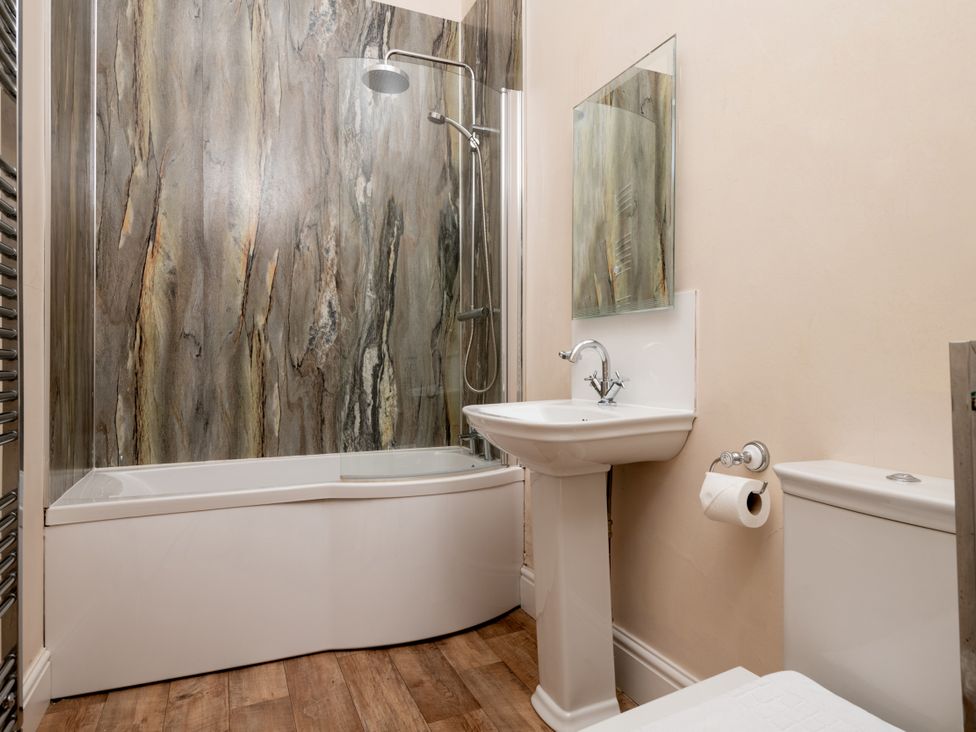 A bathroom with a bathtub, sink, and toilet at The Downwood in Blandford Forum