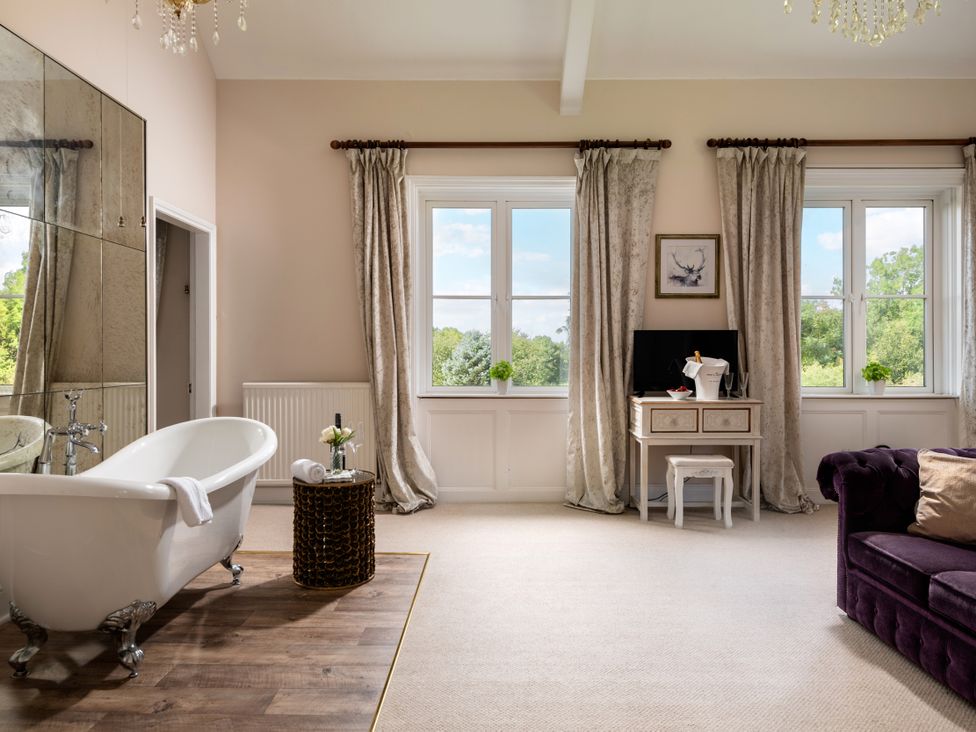 A bathroom with a bathtub and windows at The Downwood in Blandford Forum