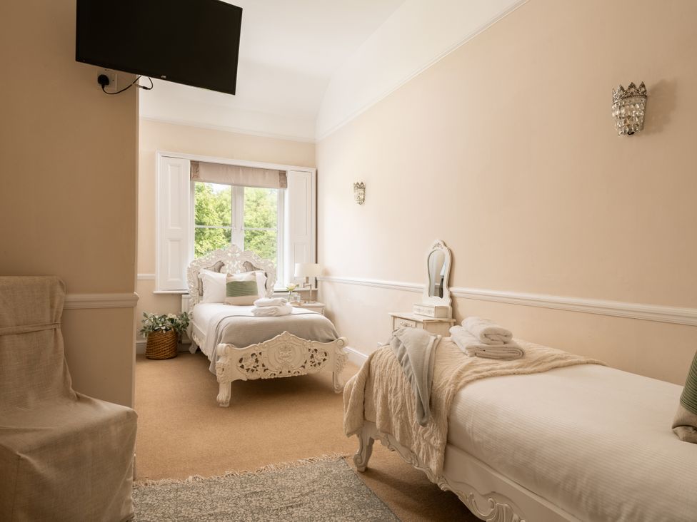 A bedroom with two beds and a tv at The Downwood in Blandford Forum