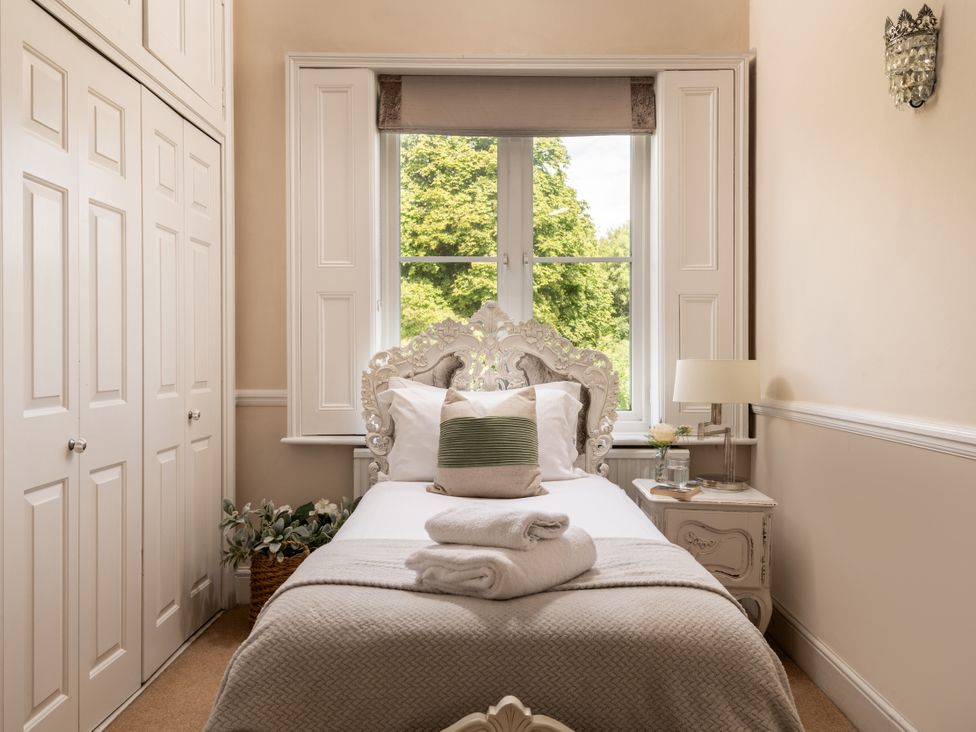 A bedroom featuring a bed with pillows and a window at The Downwood in Blandford Forum