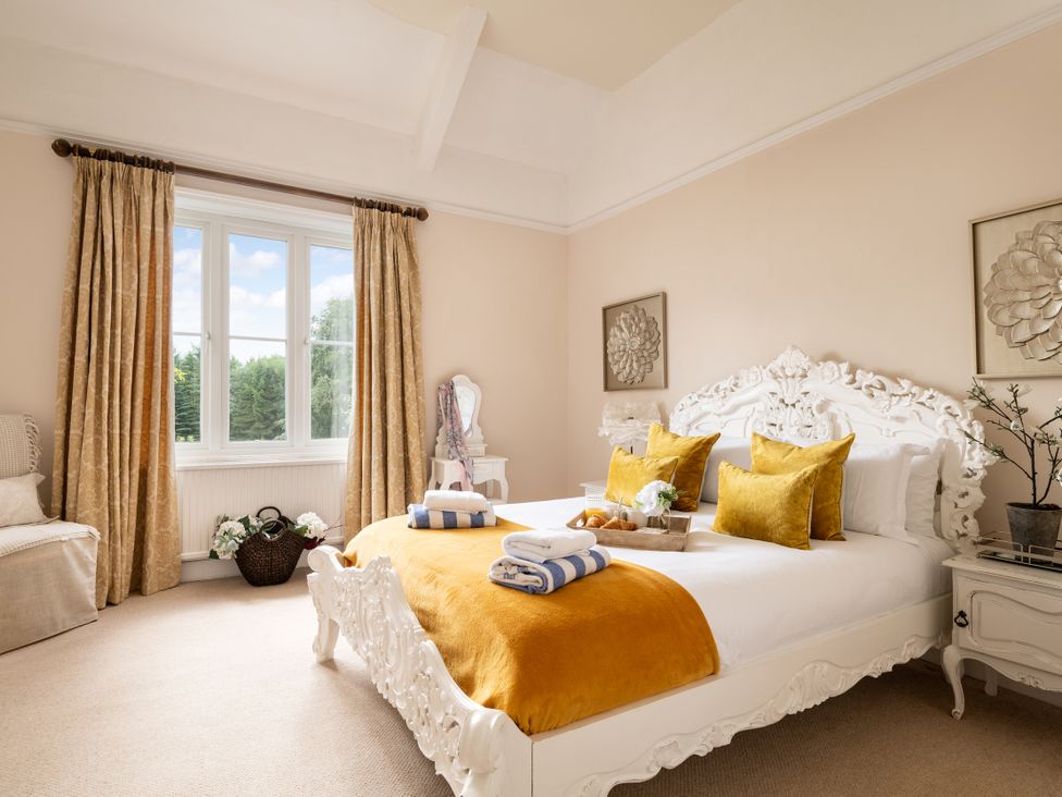 A bedroom featuring a bed with pillows and decorative items at The Downwood in Blandford Forum