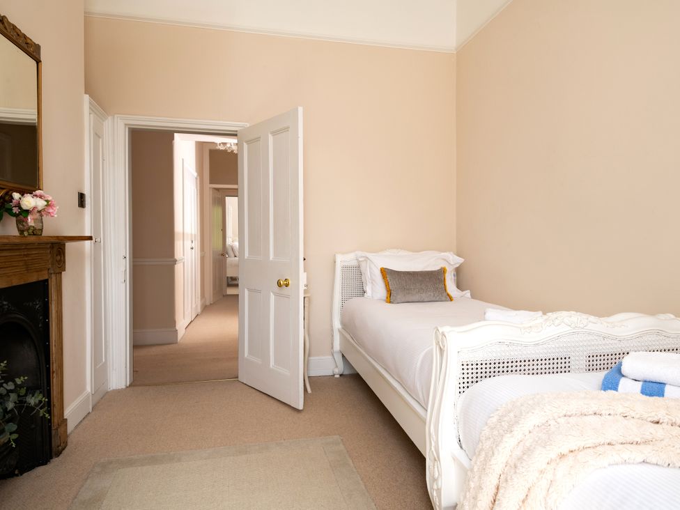 A bedroom with a bed and a door leading to another room at The Downwood in Blandford Forum