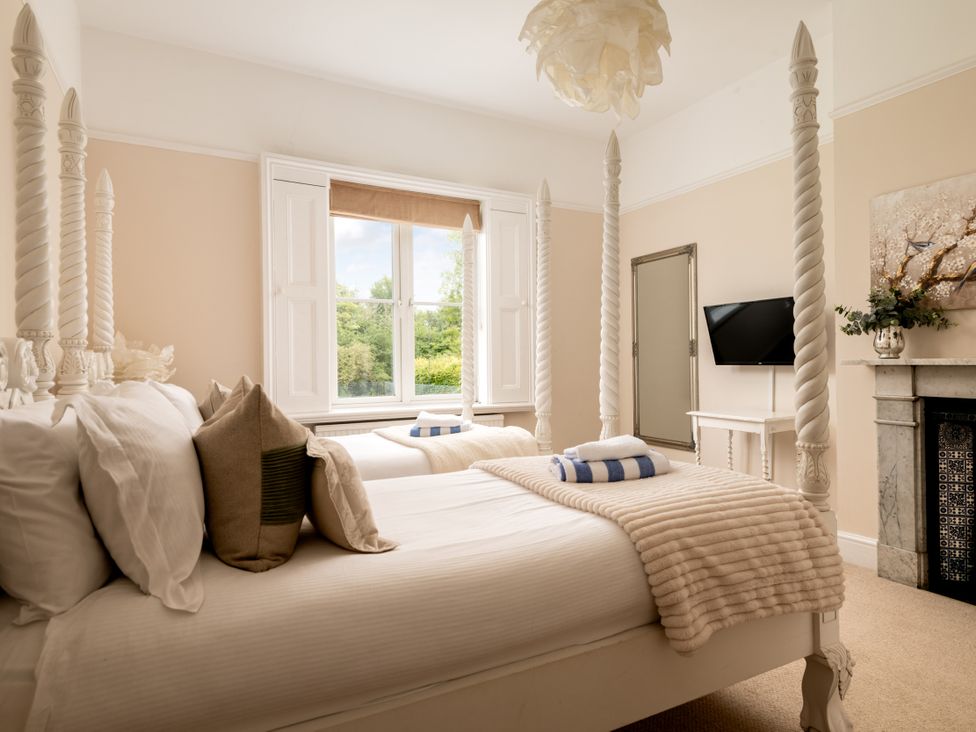 A bedroom with two beds and a television at The Downwood in Blandford Forum