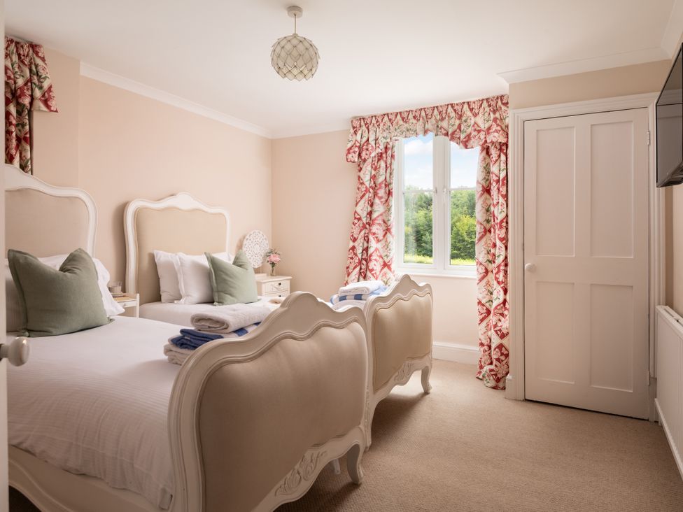 A bedroom with two beds and a window at The Downwood in Blandford Forum