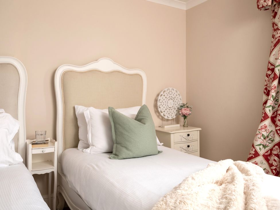 A bedroom with twin beds and a bedside table at The Downwood in Blandford Forum
