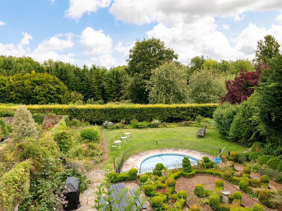 A garden with a pool and seating area at The Downwood in Blandford Forum