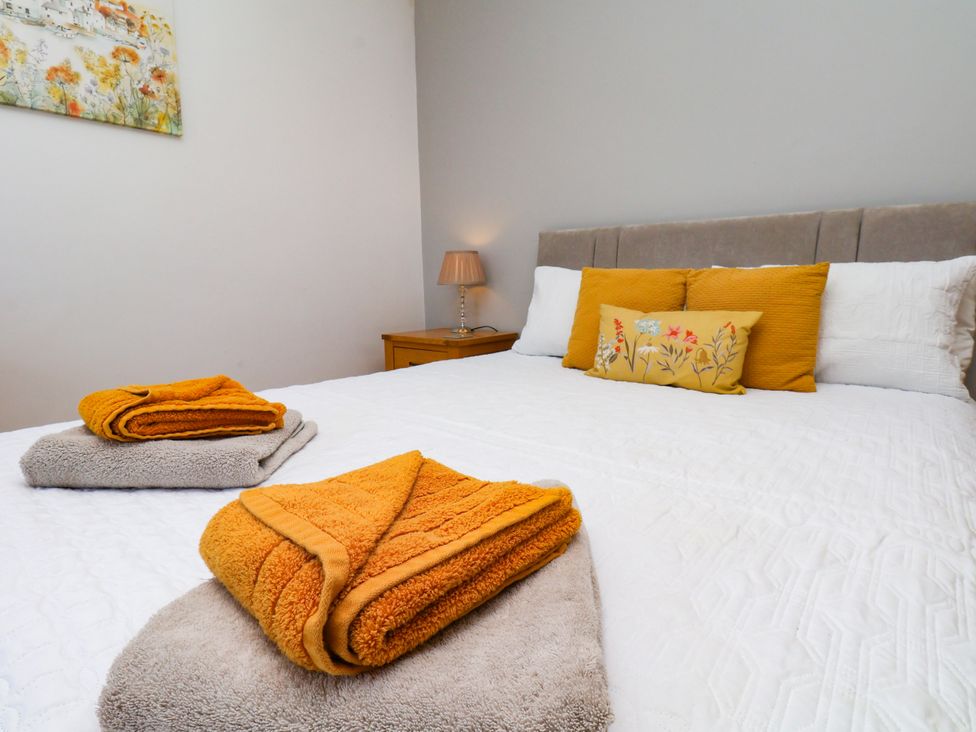 A bedroom with a bed and towels at Crabtree Cottage in Suffield near Scalby