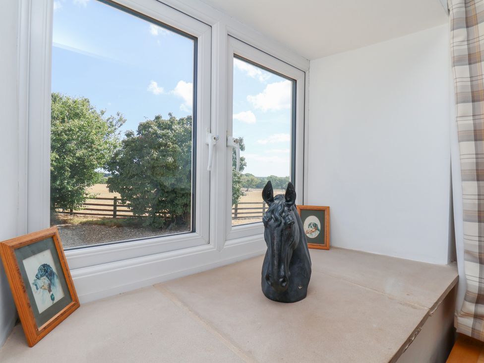 A sitting area with a horse sculpture and framed pictures at Crabtree Cottage Suffield near Scalby
