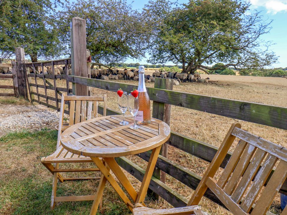 A table and chairs with drinks overlooking a field at Crabtree Cottage in Suffield near Scalby