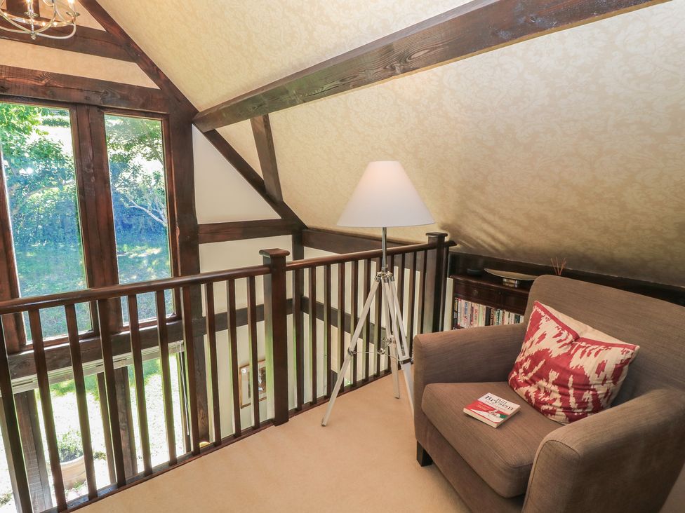 A loft with a lamp and armchair at The Barn at Frog Pond Farm Antsy near Tisbury