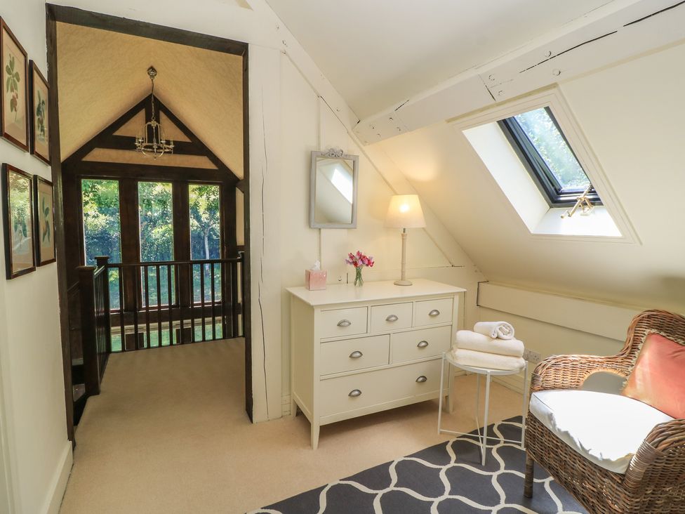 A landing area with a chest of drawers and a mirror at The Barn at Frog Pond Farm Antsy near Tisbury