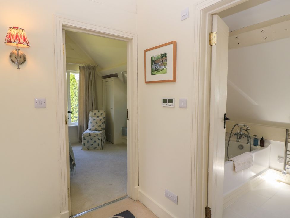 A bathroom with a bathtub and a chair at The Barn at Frog Pond Farm Antsy near Tisbury