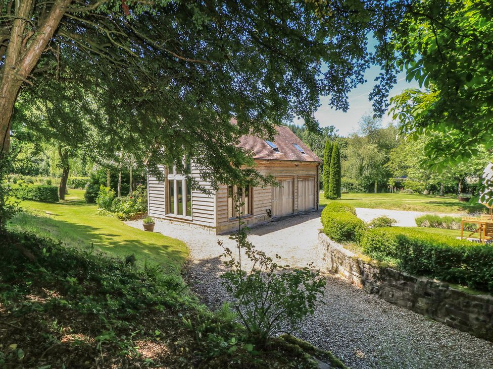 An exterior view of a building surrounded by greenery at The Barn at Frog Pond Farm near Tisbury