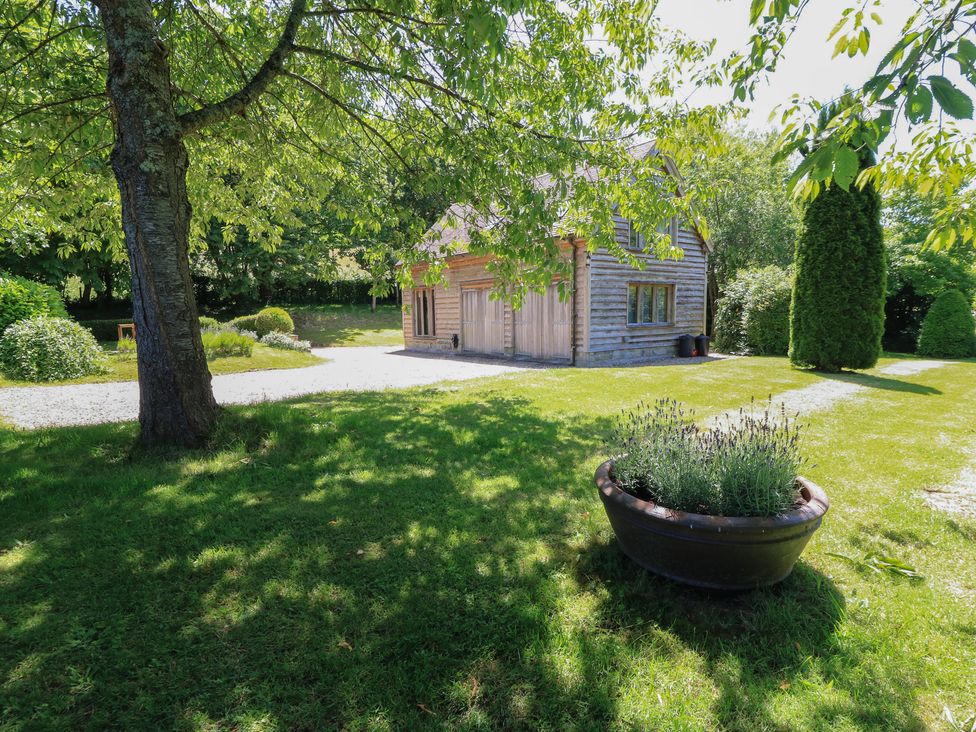A building surrounded by grass and trees at The Barn at Frog Pond Farm in Antsy near Tisbury