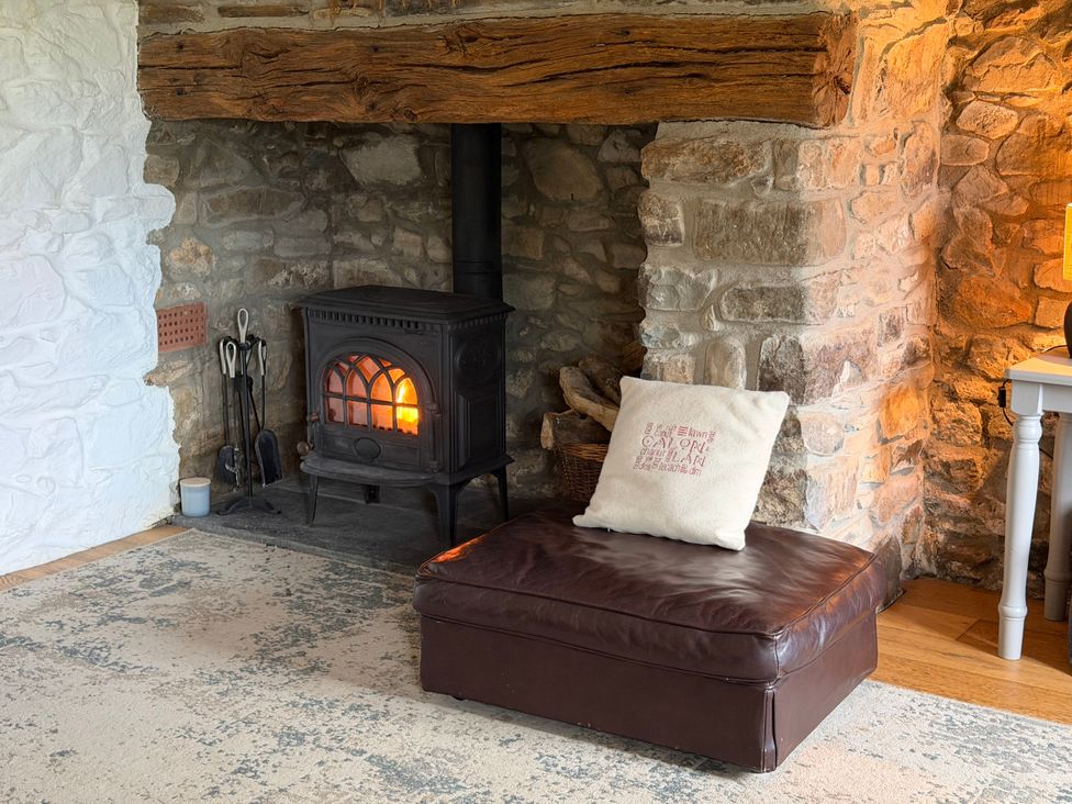 A living room with a fireplace and a seating area at Stable Cottage Newport, Pembrokeshire