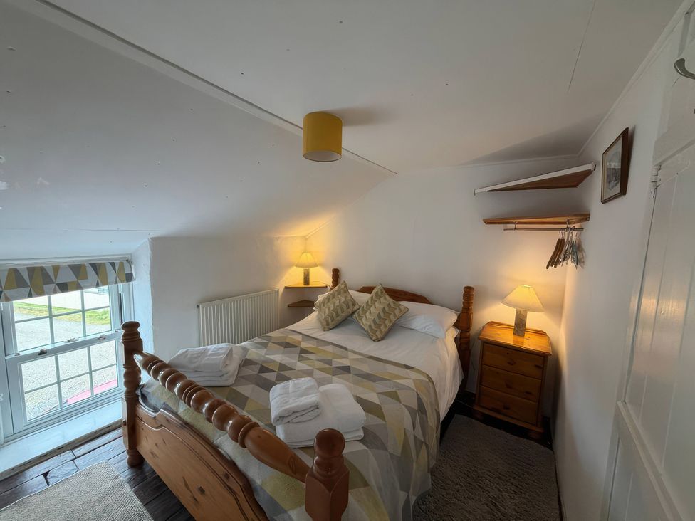 A bedroom with a bed and window at Derlwyn, Newport, Pembrokeshire