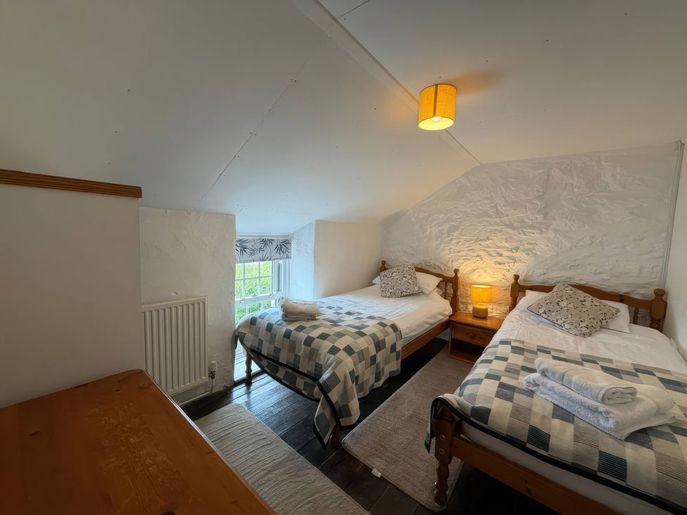 A bedroom with two beds and a window at Derlwyn in Newport, Pembrokeshire