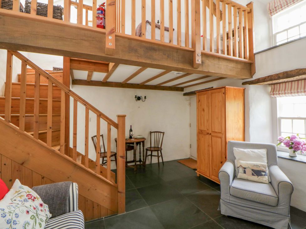 A living room featuring a dining table and chairs at West End Cottage Newport, Pembrokeshire