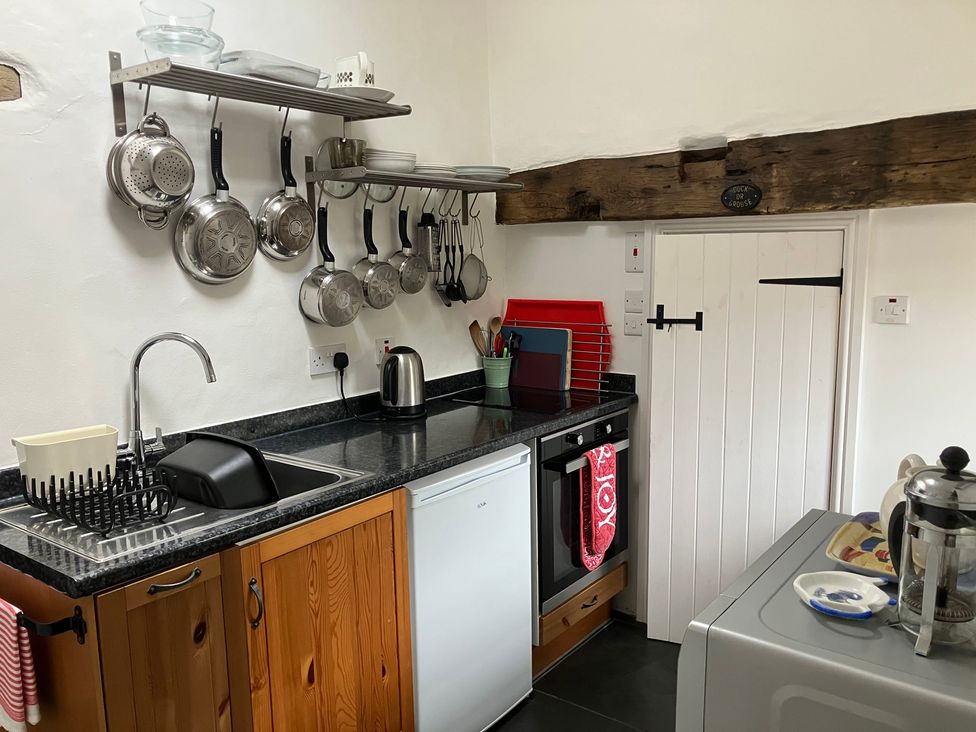 A kitchen with a sink and appliances at West End Cottage in Newport, Pembrokeshire