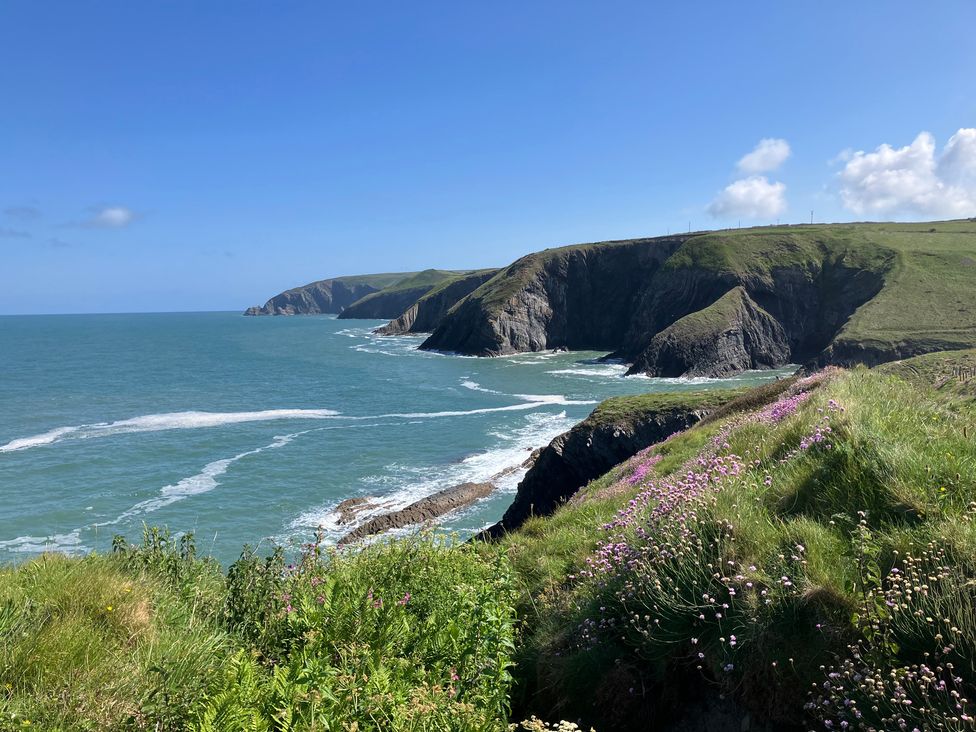 A coastal view with cliffs and waves at West End Cottage Newport, Pembrokeshire