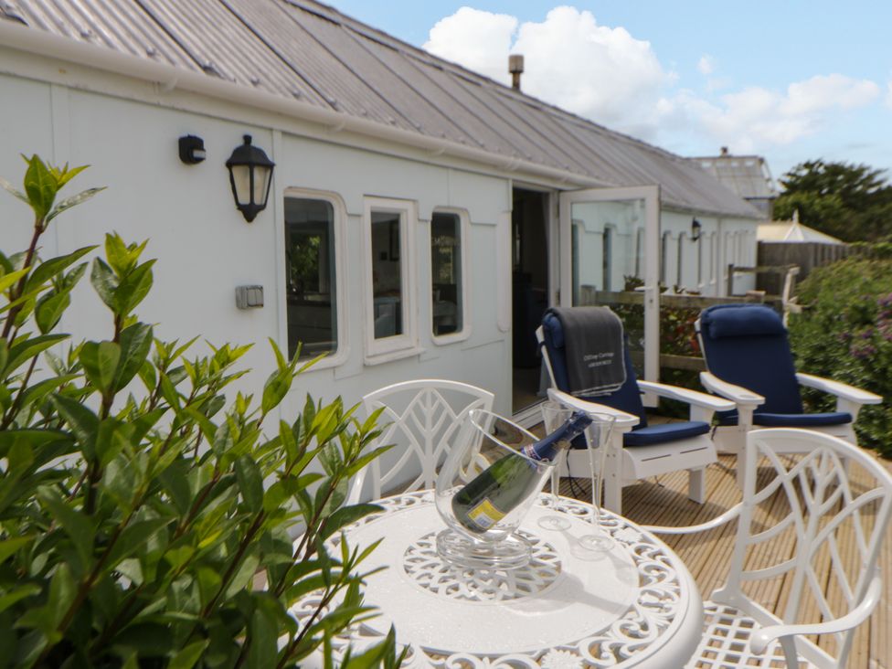 An outdoor area with a table and chairs at Clifftop Carriage in Aberporth, Ceredigion