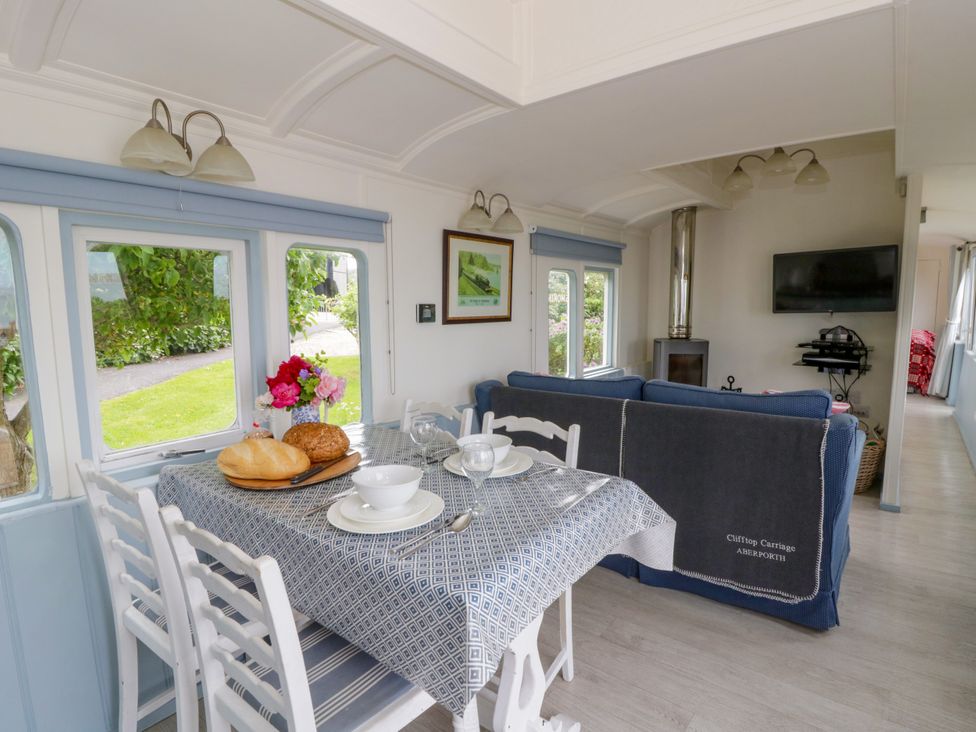 A dining room with a table set for meals at Clifftop Carriage Aberporth