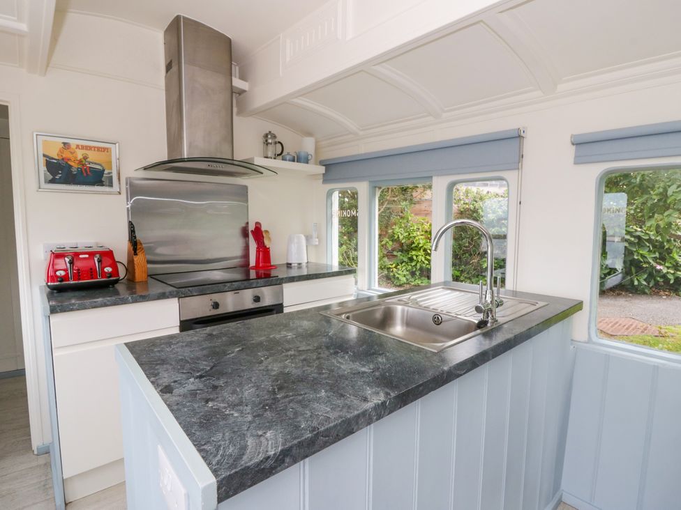 A kitchen with a sink and stove at Clifftop Carriage in Aberporth, Ceredigion