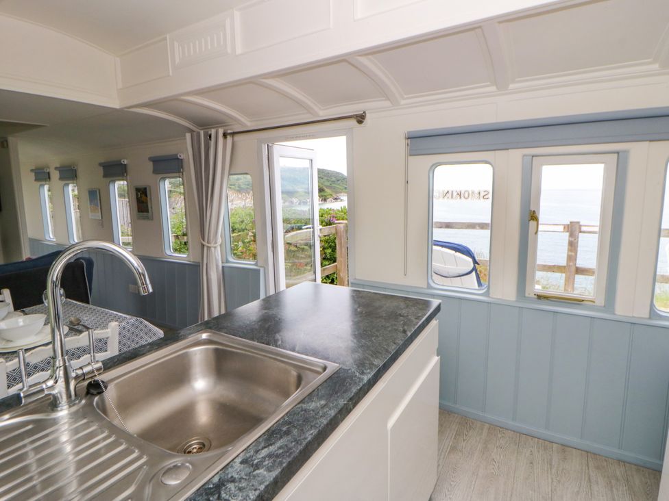 A kitchen with a sink and windows at Clifftop Carriage in Aberporth, Ceredigion