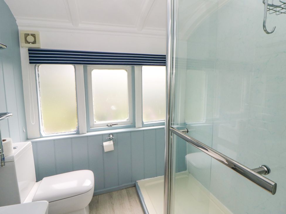 A bathroom with a toilet and a shower at Clifftop Carriage, Aberporth, Ceredigion