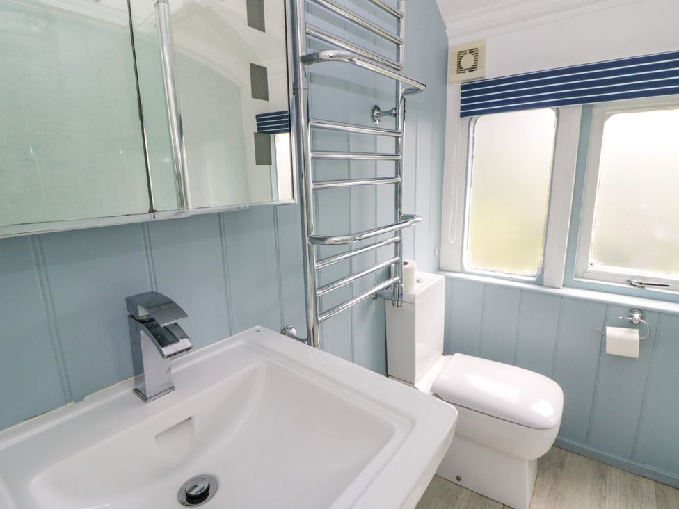 A bathroom with a sink and a toilet at Clifftop Carriage in Aberporth, Ceredigion