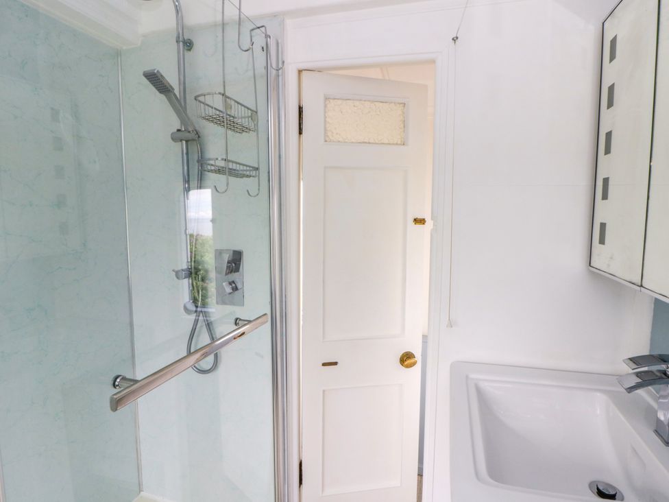 A bathroom with a shower and sink at Clifftop Carriage in Aberporth, Ceredigion
