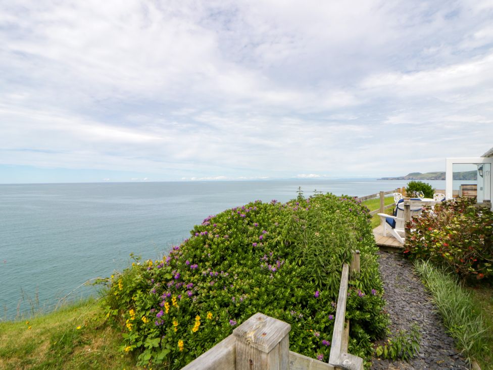 A scenic view of the ocean and plants at Clifftop Carriage in Aberporth, Ceredigion