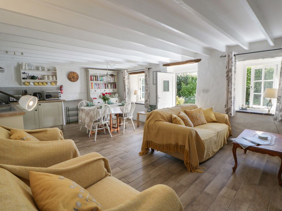 A living room with a sofa and dining table at End Cottage, Newport, Pembrokeshire