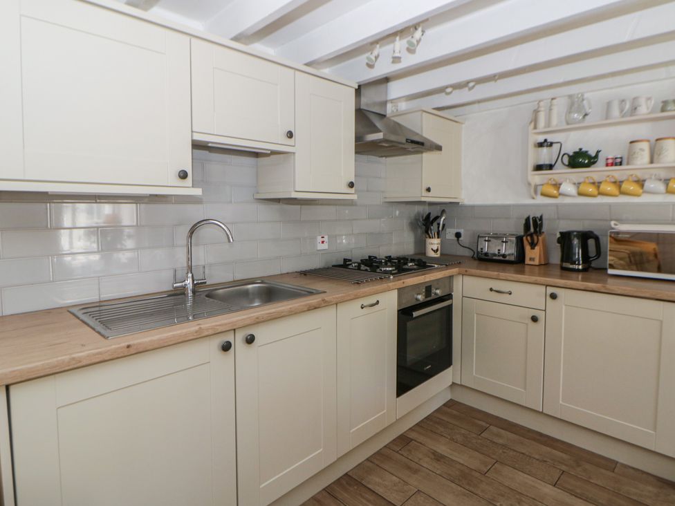 A kitchen with sink, stove, and oven at End Cottage in Newport, Pembrokeshire