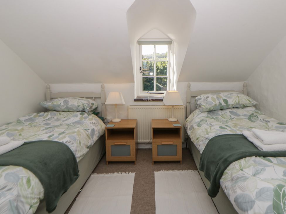 A bedroom with two beds and a window at End Cottage Newport, Pembrokeshire