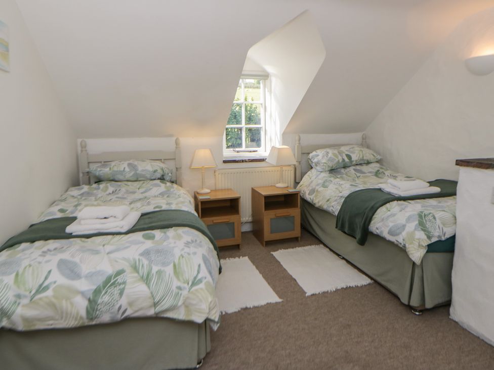 A bedroom with two beds and nightstands at End Cottage Newport, Pembrokeshire